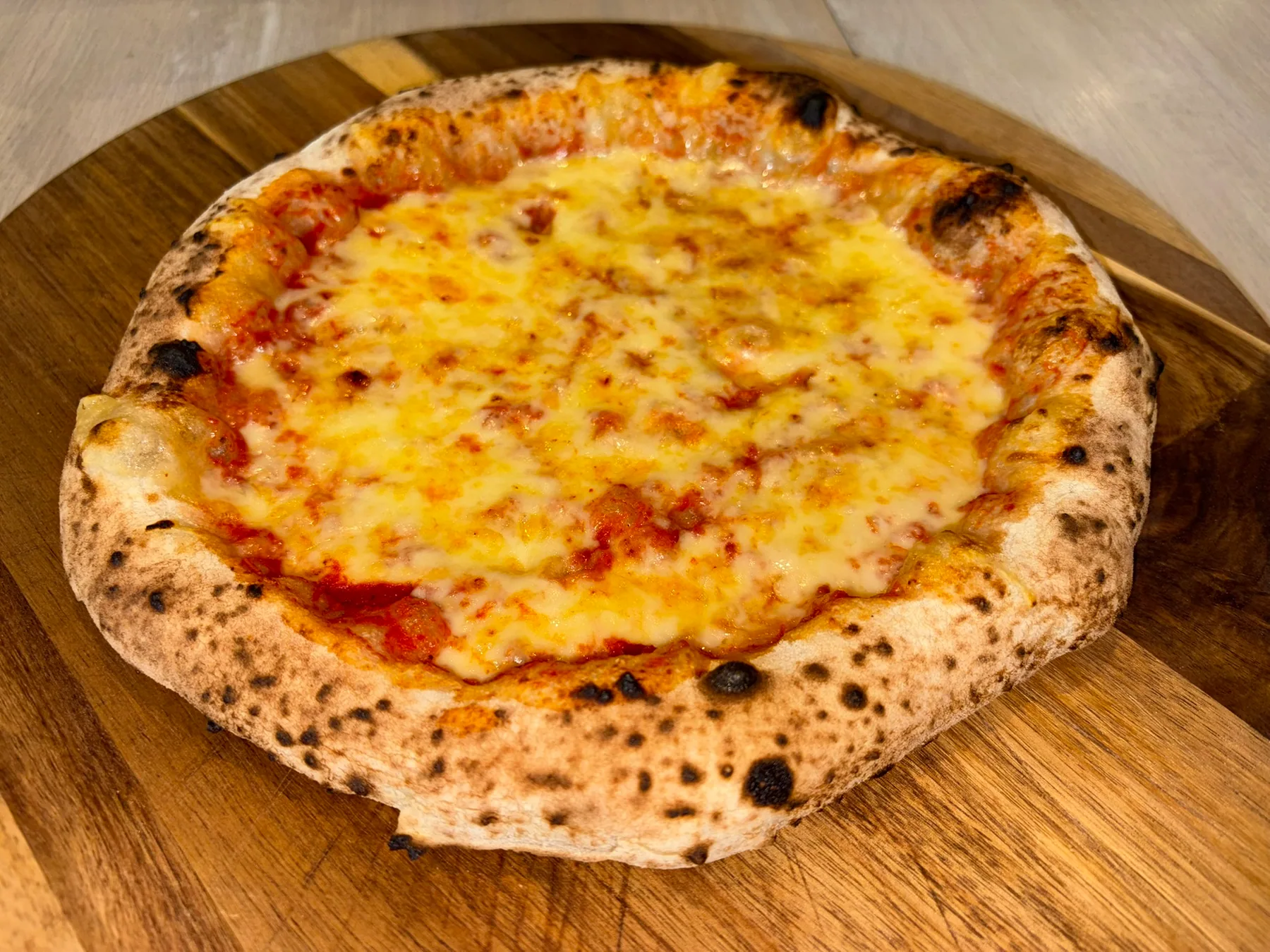 Nystekt ostepizza på et trefat