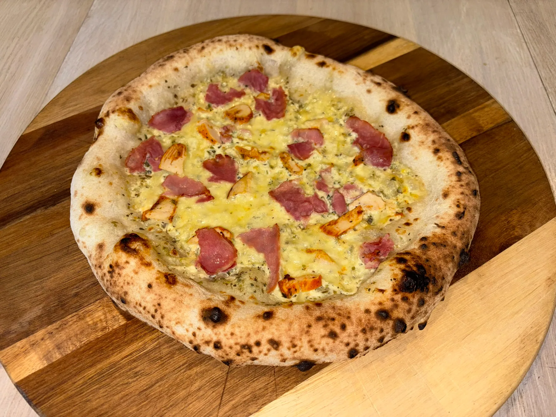Nystekt pizza med spekeskinke på et trefat